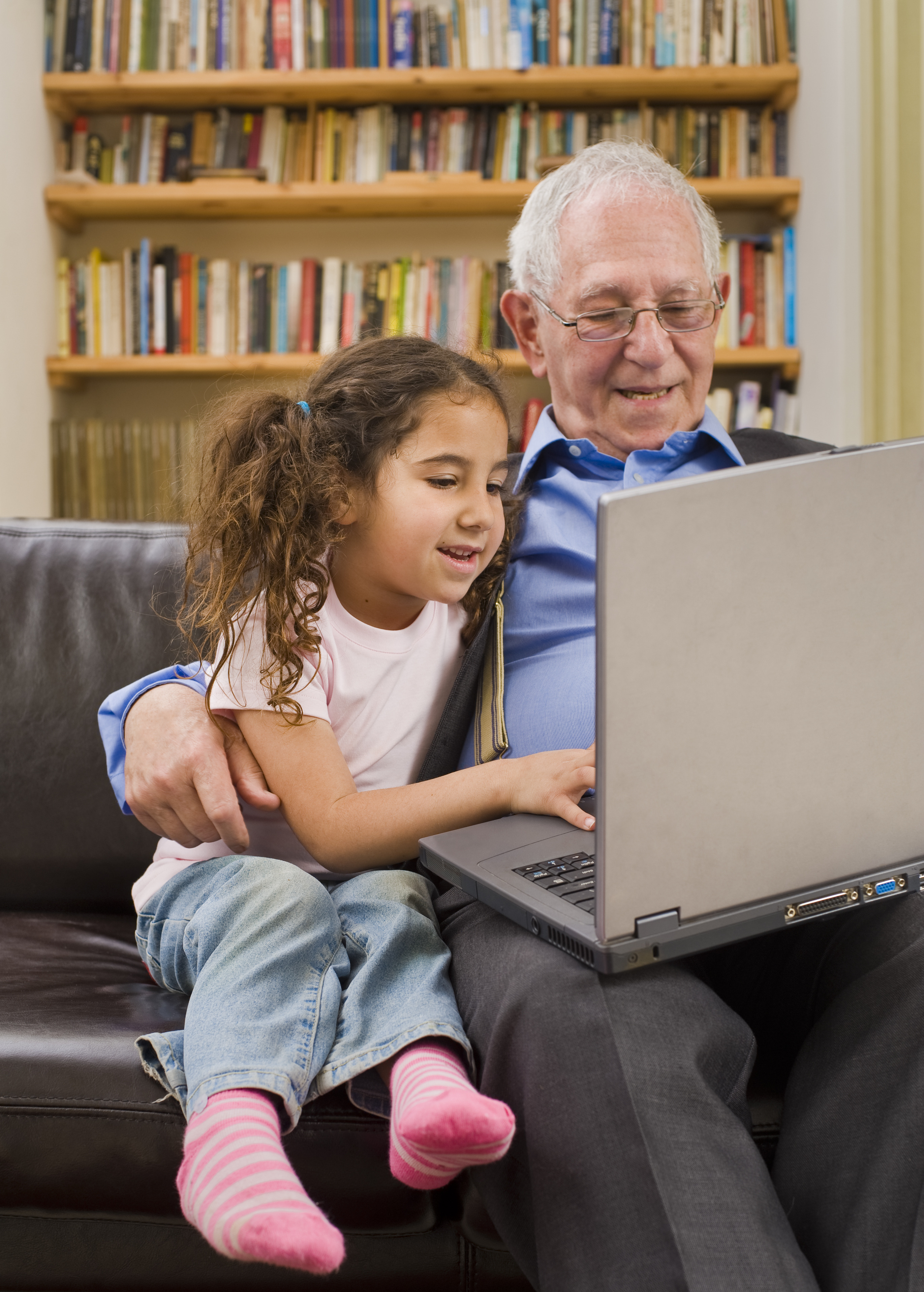 Grandparent and granddaughter with laptop computer